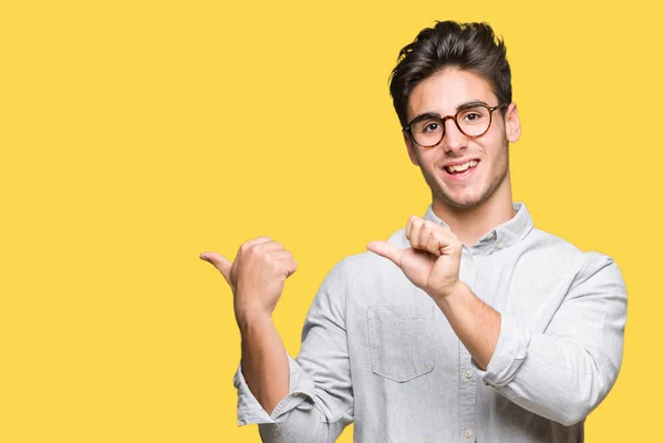 Joven Hombre Guapo Con Gafas Sobre Fondo Aislado Apuntando Espalda —  Fotos de Stock