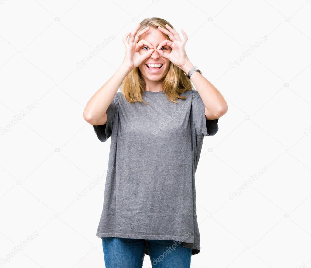 Beautiful young woman wearing oversize casual t-shirt over isolated background doing ok gesture like binoculars sticking tongue out, eyes looking through fingers. Crazy expression.