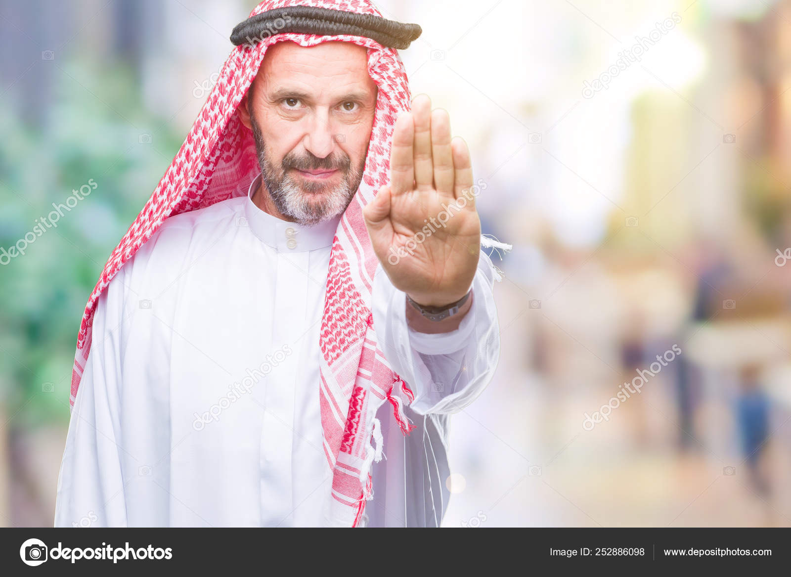 シニアのアラブ人は 孤立したバック グラウンド停止歌う手のひら上クーフィーヤを着てします 顔に否定的な深刻なジェスチャーで警告式 ストック写真 C Krakenimages Com