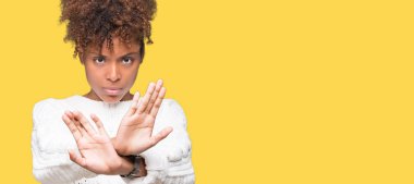 İzole arka plan ret ifade geçiş silah ve avuç içi eksi işareti, kızgın surat yapıyor üzerinde kış kazak giyen güzel genç Afro-Amerikan kadın