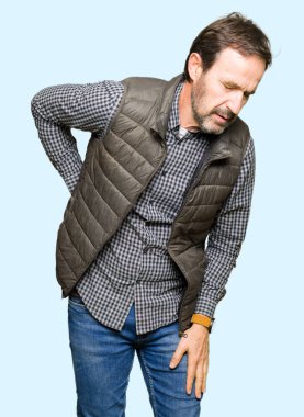 Orta yaş yakışıklı adam giyen kış acı dokunmadan el ile geri, kas ağrısı, sırt ağrısı, yelek