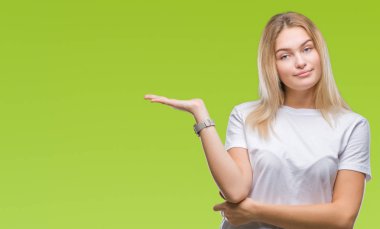 Neşeli sunulması ve kameraya bakarak avucunun ile işaret gülümseyen izole arka plan üzerinde beyaz kadın.