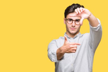 Elle yapma çerçeve ve parmakları ile mutlu yüz gülümseyen izole arka plan üzerinde gözlük takan yakışıklı delikanlı. Yaratıcılık ve Fotoğrafçılık kavramı.