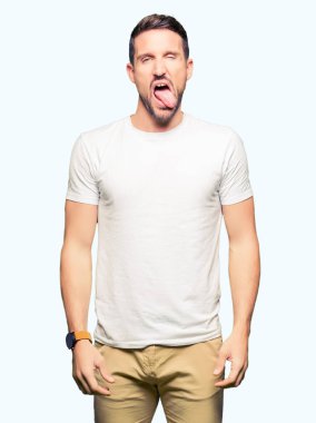 Casual beyaz t-shirt yapışma dil giyen yakışıklı adam out komik ifade ile mutlu. Duygu kavramı.