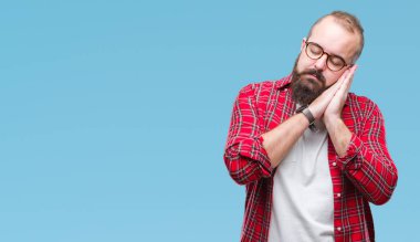 Uyku yorgun hayal ve ellerle birlikte poz ile kapalı gözler gülümseyen izole arka plan üzerinde gözlük takan Genç beyaz hipster adam.