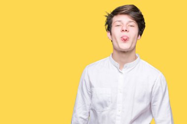 Genç yakışıklı iş adamı dilini izole arka plan üzerinde out komik ifade ile mutlu. Duygu kavramı.