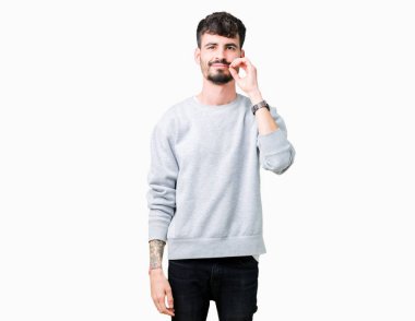 Üzerinde sweatshirt giyen genç yakışıklı adam arka plan ağız izole ve parmak ile ZIP olarak Dudaklarını kapa. Gizli ve sessiz, tabu söz