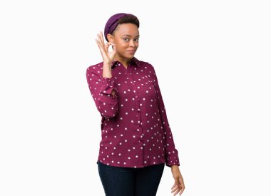 İzole arka plan el ve parmaklar ok işaretiyle yapıyor olumlu gülümseyen üzerinde başörtüsü giyen güzel genç Afro-Amerikan kadın. Başarılı ifade.