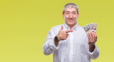 Yakışıklı komuta sizde para demet izole arka plan üzerinde çok mutlu el ve parmak ile işaret tutan