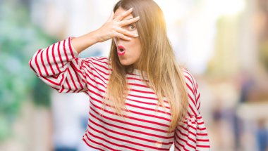 Genç güzel kadın rahat kış kazak yüz ve gözler el ile kapsayan şok izole arka plan bakmak üzerinde çizgili mahcup ifadeyle parmaklarımın arasından arıyorsunuz.