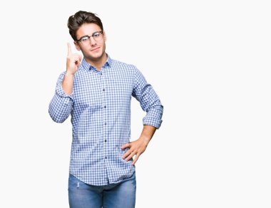 Başarılı fikirle izole arka plan işaret parmağı üzerinde gözlük takan yakışıklı delikanlı. Çıktıktan ve mutlu. Bir numara.