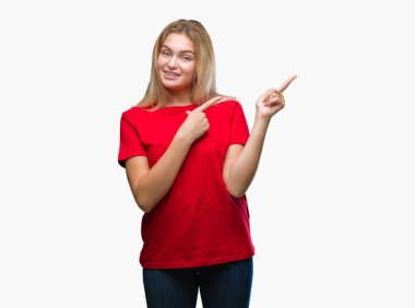 Gülümseyen ve iki elleri ve parmakları ile tarafına işaret kamera bakarak izole arka plan üzerinde beyaz kadın.