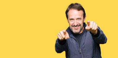 Orta yaş yakışıklı adam bir ceket ve kameranın olumlu ve neşeli gülümseyen parmaklarıyla işaret