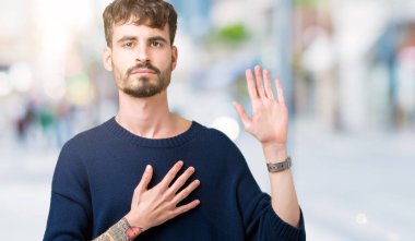 Yakışıklı delikanlı izole arka plan üzerinde göğüs ve bir sadakat sözü yemin yapma avuç, el ile küfür