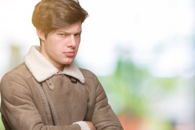 Genç yakışıklı giyen kış ceket izole arka plan şüpheci ve sinir, onaylamayan ifade yüz çapraz kolları olan adam. Negatif kişi.