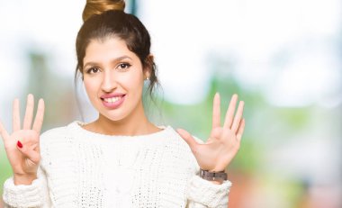 Gösterilen ve parmakları ile işaret genç güzel kadın giyiyor kış kazak numara 9 kendinden emin ve mutlu gülümseyerek süre.