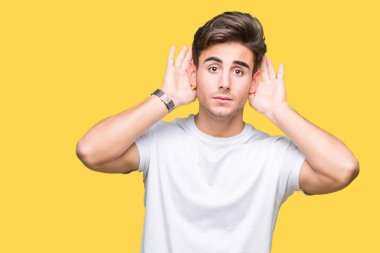 Her ikisi de dinliyoruz izole arka plan üzerinde beyaz t-shirt giyen genç yakışıklı adam kulak jest, dedikodu için meraklı eller. İşitme sorunu, sağır