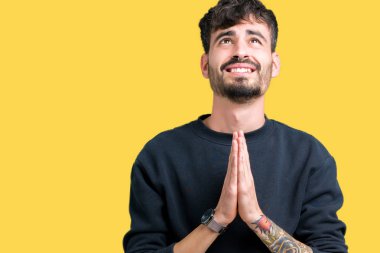 Yakışıklı delikanlı yalvarıyor ve umut ifade yüzünde çok duygusal ve endişe ile birlikte elleriyle dua izole arka plan üzerinde. Bağışlanmak. Din kavramı.
