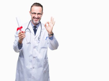 Orta yaş üst düzey ağarmış Doktor adam derecesi sertifika parmak, mükemmel sembolü ile ok işareti yapıyor izole arka plan üzerinde tutan