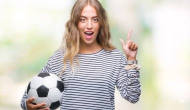 Futbol futbol topu izole arka plan üzerinde bir fikir ya da soru işaret parmağı gülen yüz, bir numara ile sürpriz tutan genç güzel sarışın kadın