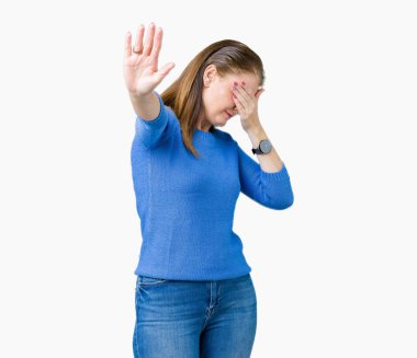 Güzel orta yaş olgun elleriyle gözlerini kapsayan izole arka plan üzerinde kış kazak giyen kadın ve stop jest ile acı ve korku ifadesi. Utandım ve negatif kavramı.