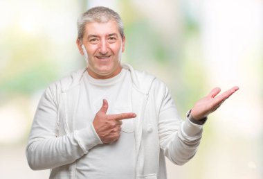 Üst düzey yakışıklı hayrete ve el ile sunulması ve parmak ile işaret ederken kameraya gülümseyen izole arka plan üzerinde spor giyim eşyası.