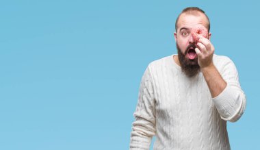 Genç beyaz hipster adam izole arka şok sürpriz yüzü, korkuyor ve korku ifadesi ile heyecanlı olan korkmuş üzerinde tatlı çörek yeme