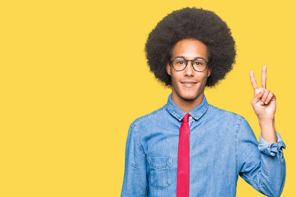 非洲青年商人与非洲头发戴眼镜和红色领带显示和指向用手指第二 同时微笑着自信和快乐 — 图库照片
