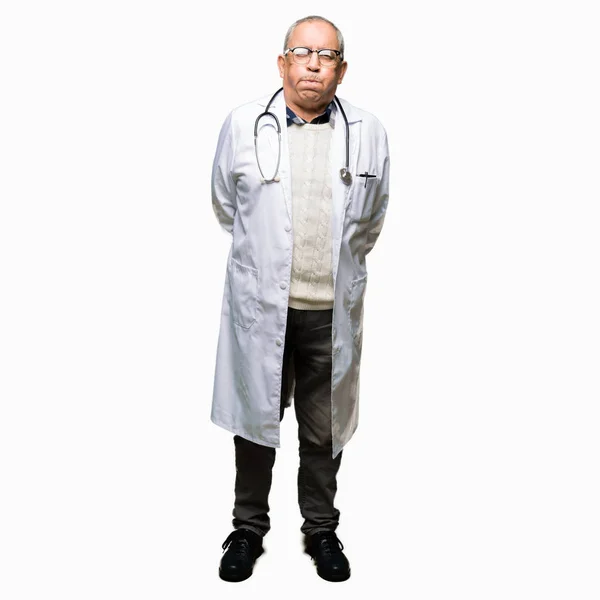 Όμορφος Ανώτερος Γιατρός Άνθρωπος Φορώντας Ιατρική Παλτό Ξεφυσώντας Μάγουλα Αστείο — Φωτογραφία Αρχείου