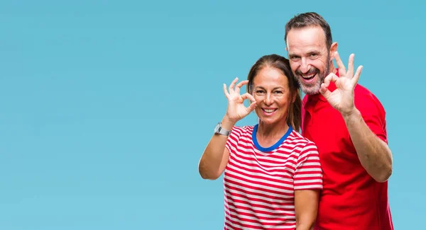 中年西班牙夫妇在爱在孤立的背景微笑正面做确定的标志用手和手指 成功的表达 — 图库照片
