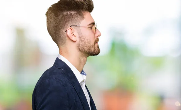 Young handsome elegant man wearing sunglasses and fashion blazer looking to side, relax profile pose with natural face with confident smile.