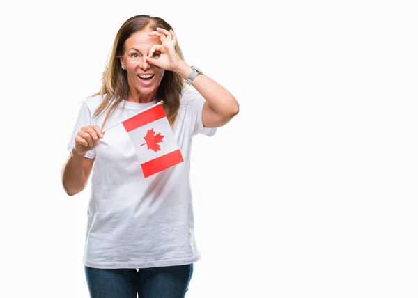 中世纪拉美裔妇女持有加拿大国旗在孤立的背景和快乐的脸微笑做 标志用手在眼睛看通过手指 — 图库照片