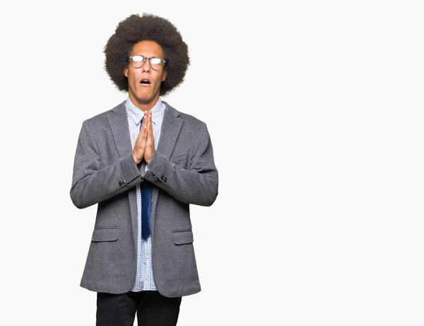 年轻的非洲裔美国商人戴着非洲头发 戴着眼镜乞讨和祈祷与双手在一起 希望表情在脸上很情绪化和担心 请求宽恕 宗教概念 — 图库照片
