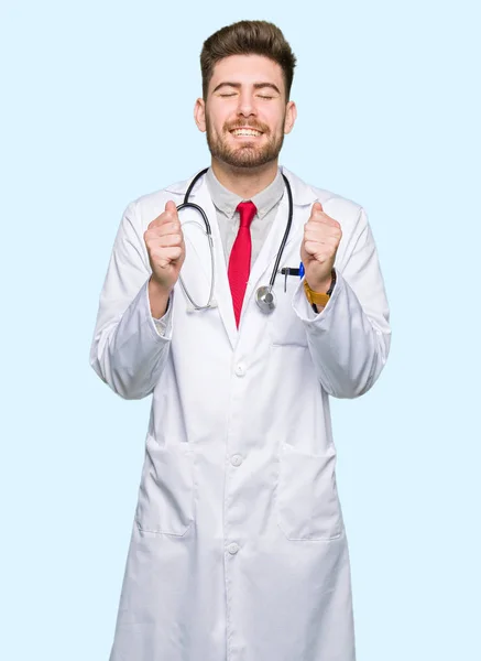 Młody Przystojny Lekarz Człowiek Sobie Herb Medycznych Podekscytowany Sukces Ramionami — Zdjęcie stockowe