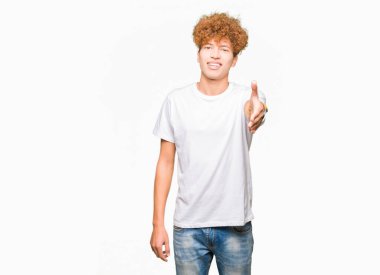 Tebrik ve konuksever dost sunan karşılıklı gülümseyen casual beyaz t-shirt giyen afro saçlı genç yakışıklı adam. Başarılı iş.