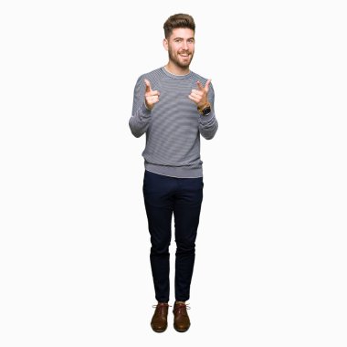 Çizgili süveter işaret parmak kamera ile mutlu ve komik yüz giyen genç yakışıklı adam. İyi enerji ve vibes.