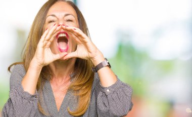 Güzel orta yaş iş kadın bağırarak ağzına eller ile yüksek sesle öfkeli