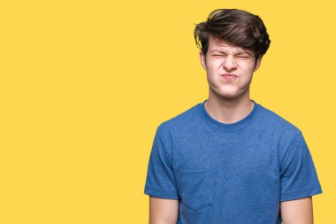 Komik surat ile yanakları şişirme izole arka plan üzerinde mavi t-shirt giyen genç yakışıklı adam. Ağız ile hava, deli ifade şişirilmiş.