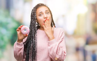 Sessizlik, gizli kavramı izole arka kapak ağız elle hata, korku, ifade için utanç ile şok üzerinde pembe çörek yiyen genç Afro-Amerikan kız korkuyor
