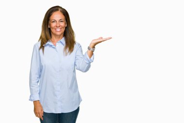 Neşeli sunulması ve kameraya bakarak avucunun ile işaret gülümseyen izole arka plan güzel orta yaş iş yetişkin kadın.