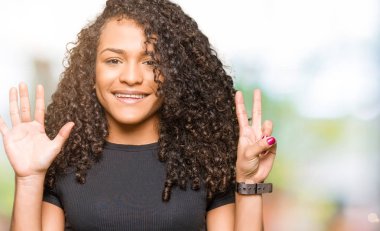 Gösterilen ve parmakları ile işaret kıvırcık saçlı Genç güzel kadın kendinden emin ve mutlu gülümseyerek süre yedi numara.