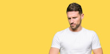 Yakışıklı erkek kol saati, rahat ve kendinden emin zamanında kontrol casual beyaz t-shirt giyen