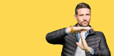 Yakışıklı adam kış ceket yapmak zaman aşımı jest elle, sinirli ve ciddi bir yüz