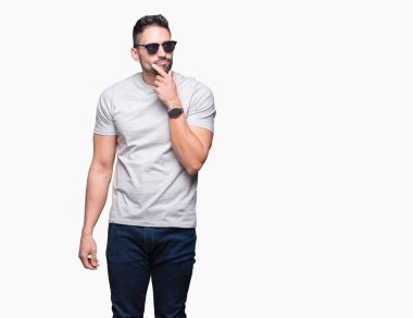 Yakışıklı delikanlı izole arka plan ciddi bir yüz düşünme hakkında soru, çok karışık bir fikir üzerinde güneş gözlüğü takıyor