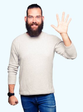 Gösterilen ve parmakları ile işaret rahat kazak giyen genç sarışın adam kendinden emin ve mutlu gülümseyerek süre beş numara.