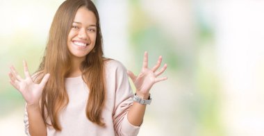 Genç güzel esmer kadın izole arka plan üzerinde pembe sweatshirt giyen deli kutluyor ve başarı için hayran silah kaldırdı ve açık gözleri heyecanlı çığlık. Kazanan kavramı