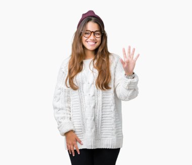 Genç güzel esmer hipster kadın gözlük ve kış şapka içeren izole arka plan üzerinde gösteren ve parmak sayısı beş ile işaret kadar güven ve mutlu gülümseyen.