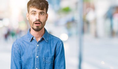 Genç yakışıklı adam korkuyor ve şok sürpriz ifade ile izole arka plan üzerinde korku ve yüz heyecanlı.