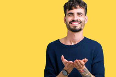 Yakışıklı delikanlı izole arka plan üzerinde gülen ellerle birlikte alma veya jest vererek palms. Ayrı tutma ve koruma