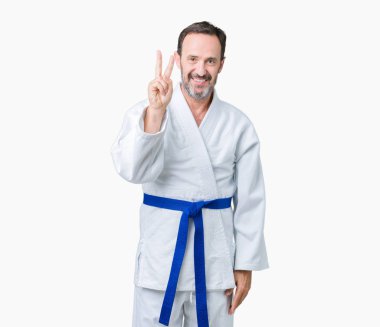 Yakışıklı orta yaş komuta sizde kimono üniforması üzerinde gösterilen arka plan izole ve parmakları ile işaret kendinden emin ve mutlu gülümseyerek ise ikinci.